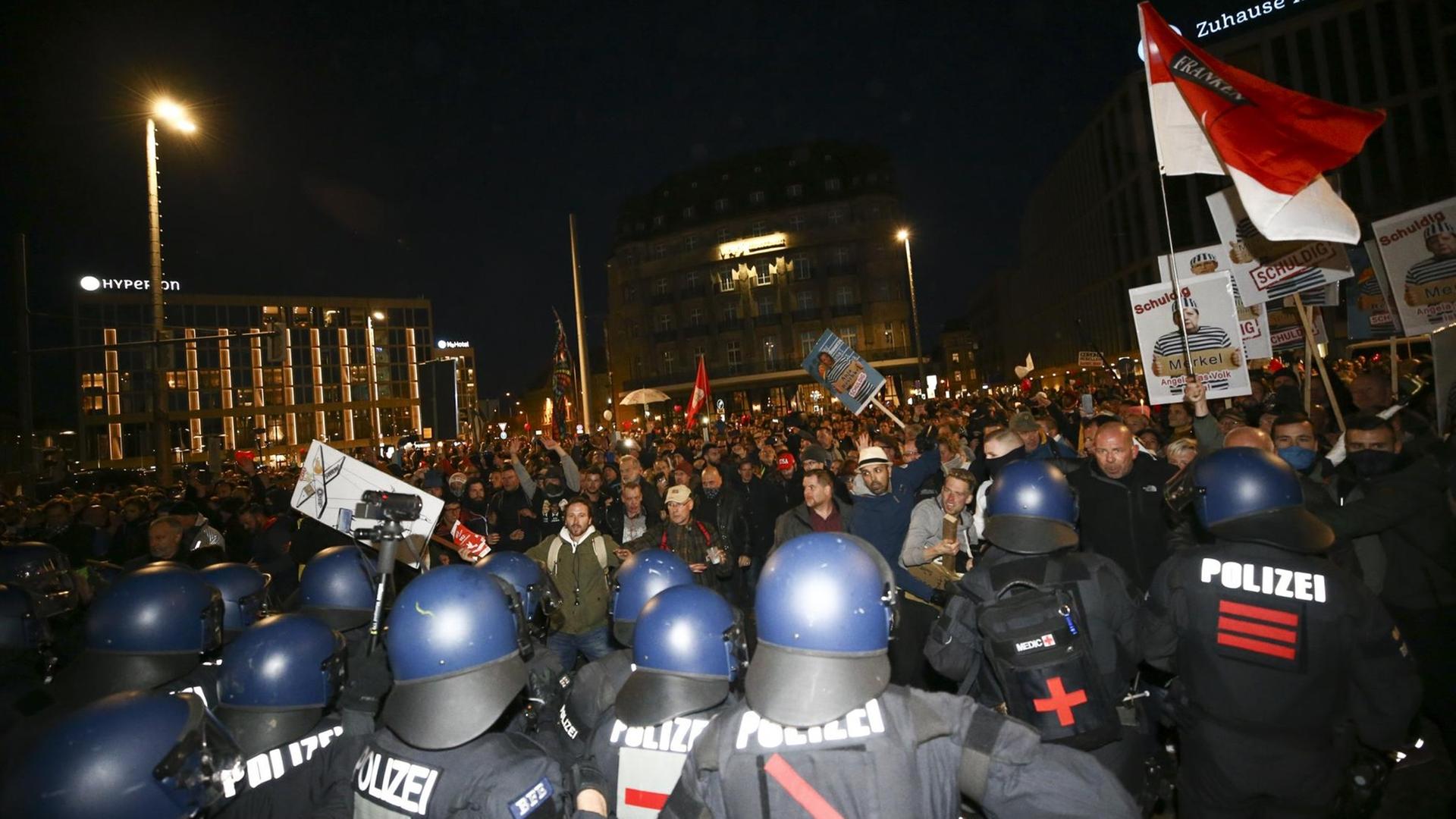 Polizeibeamte stehen in Leipzig Teilnehmern einer Demonstration gegen die Corona-Maßnahmen gegenüber Polizeibeamte stehen in Leipzig Teilnehmern einer Demonstration gegen die Corona-Maßnahmen gegenüber