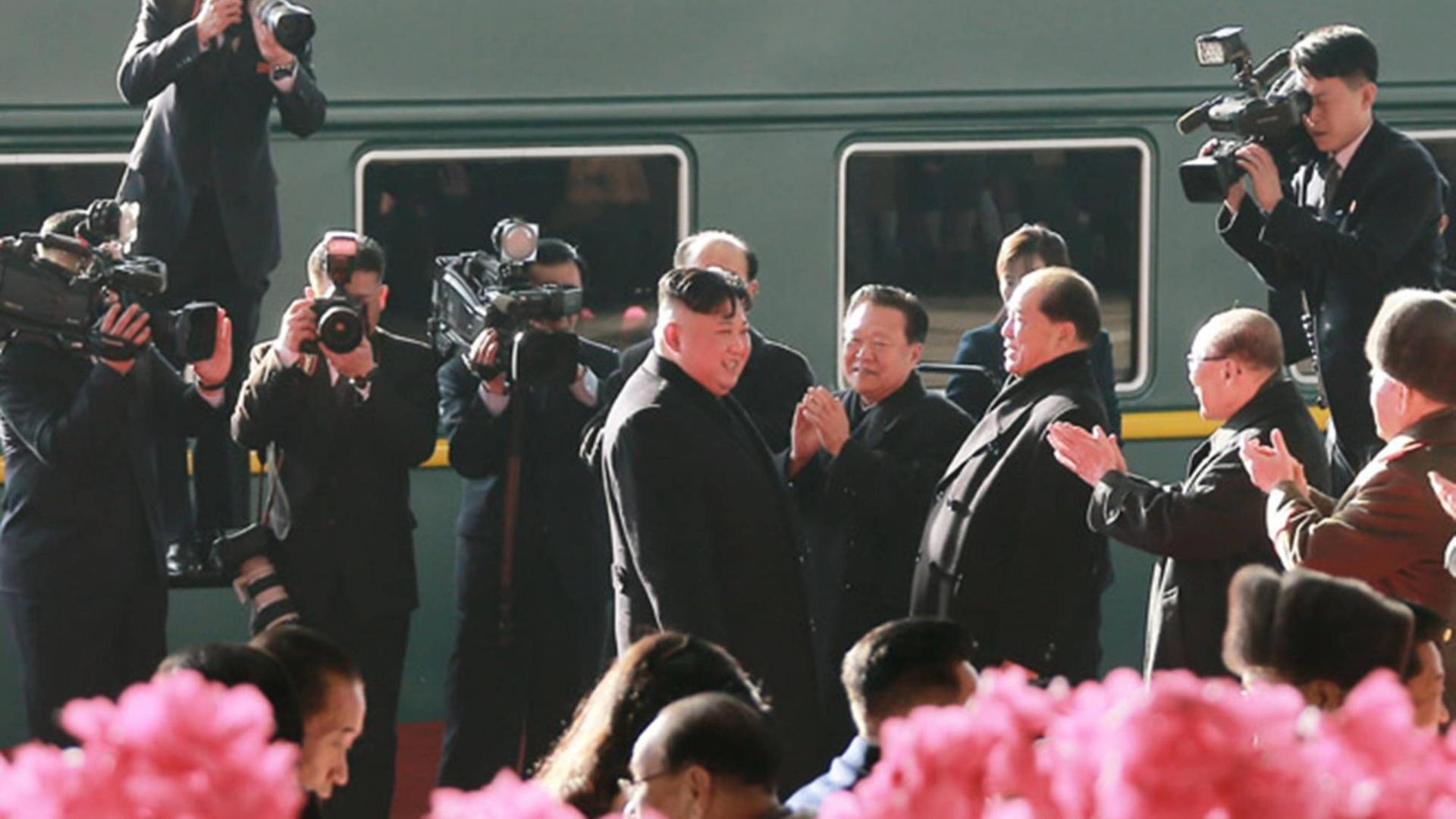 Kim Jung Un ist umringt von Kamerateams vor einem Zug zu sehen. Kim Jung Un ist umringt von Kamerateams vor einem Zug zu sehen.
