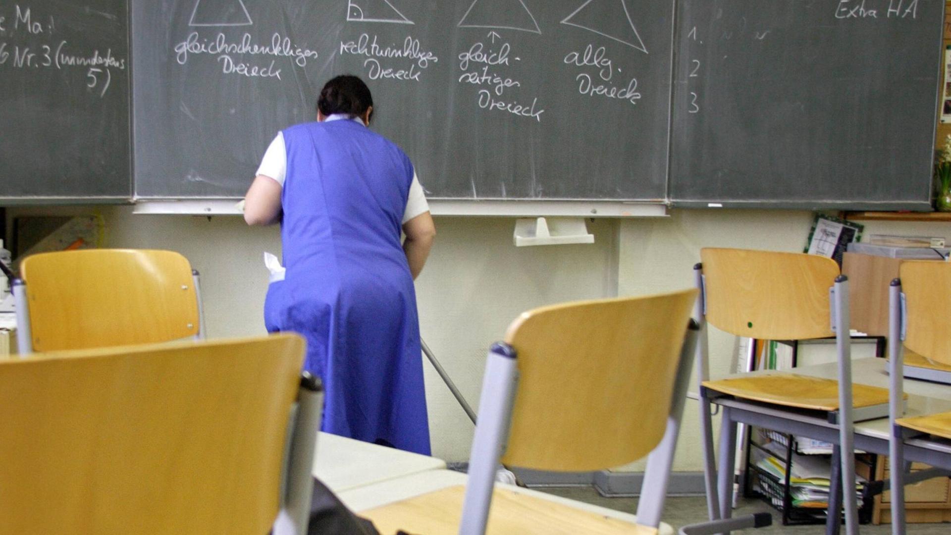 Eine Putzfrau reinigt ein Klassenzimmer in einer Grunschule in Berlin-Tempelhof. Eine Putzfrau reinigt ein Klassenzimmer in einer Grunschule in Berlin-Tempelhof.