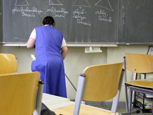 Eine Putzfrau reinigt ein Klassenzimmer in einer Grunschule in Berlin-Tempelhof.