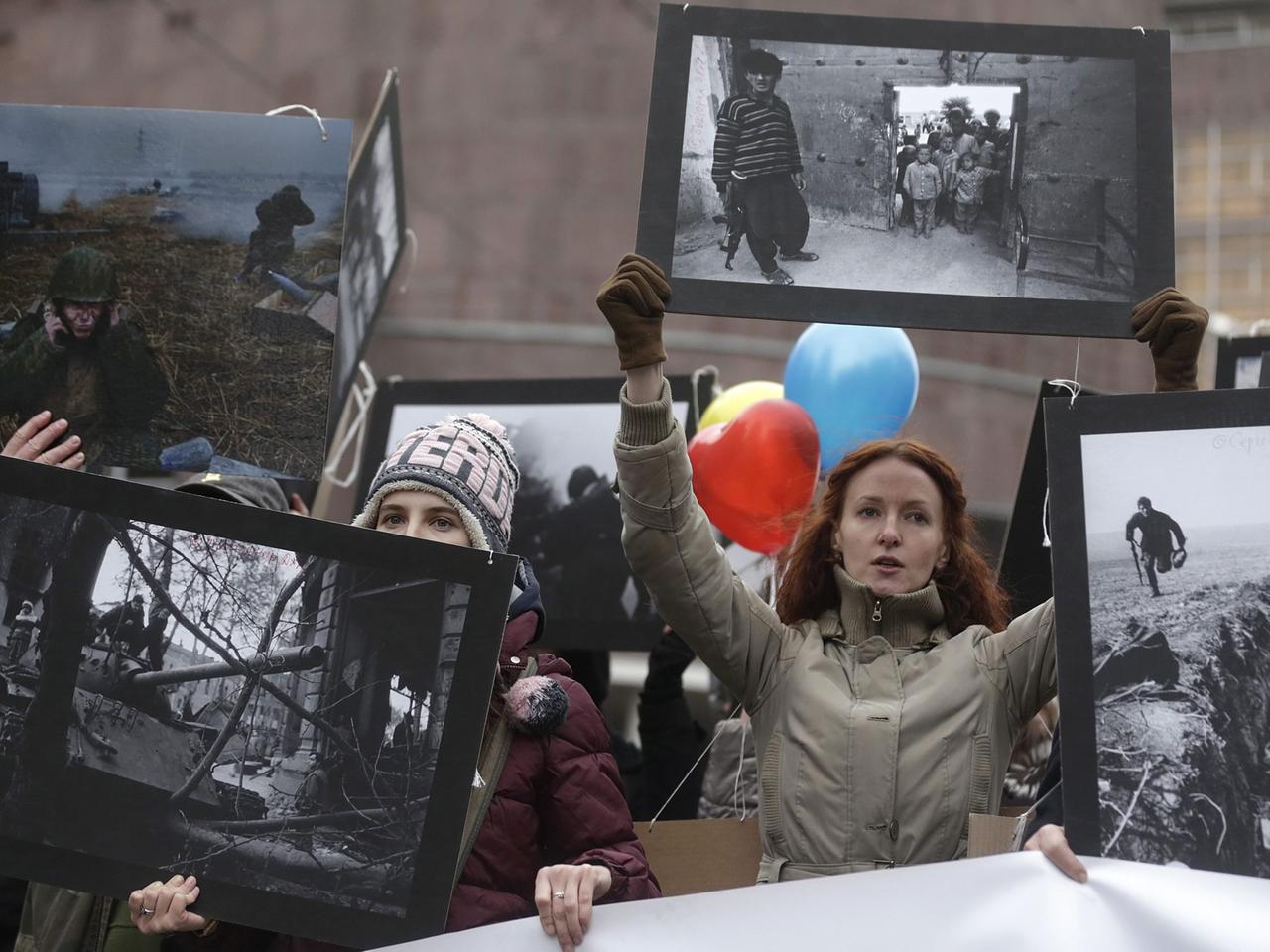 Demonstranten in Moskau zeigen Fotos aus früheren Kriegen Demonstranten in Moskau zeigen Fotos aus früheren Kriegen