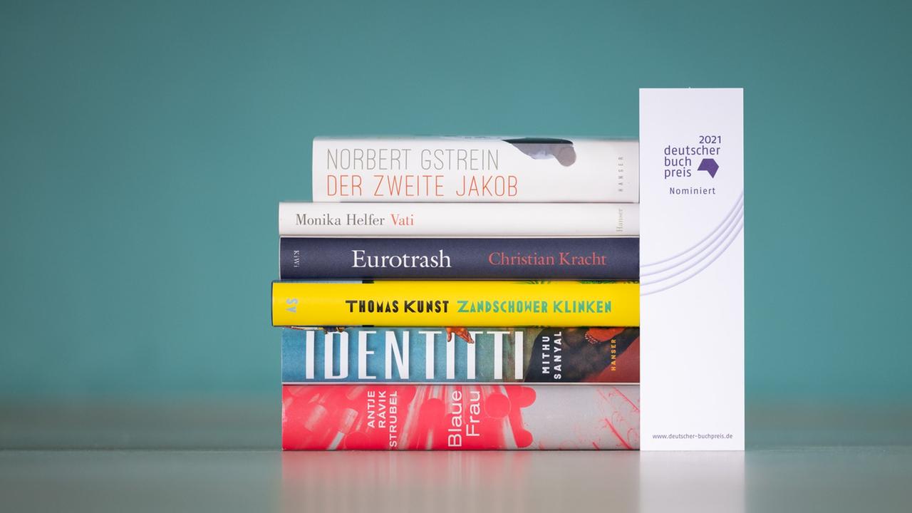 Auf dem Bild sind die Buchrücken der sechs Bücher auf der Shortlist zum Deutschen Buchpreis 2021 zu sehen: Norbert Gstrein "Der zweite Jakob"; Monika Helfer: "Vati"; Christian Kracht: "Eurotrash";Thomas Kunst: "Zandschower Klinken"; Mithu Sanyal: "Identitti"; Antje Rávik Strubel: "Blaue Frau". Auf dem Bild sind die Buchrücken der sechs Bücher auf der Shortlist zum Deutschen Buchpreis 2021 zu sehen: Norbert Gstrein "Der zweite Jakob"; Monika Helfer: "Vati"; Christian Kracht: "Eurotrash";Thomas Kunst: "Zandschower Klinken"; Mithu Sanyal: "Identitti"; Antje Rávik Strubel: "Blaue Frau".