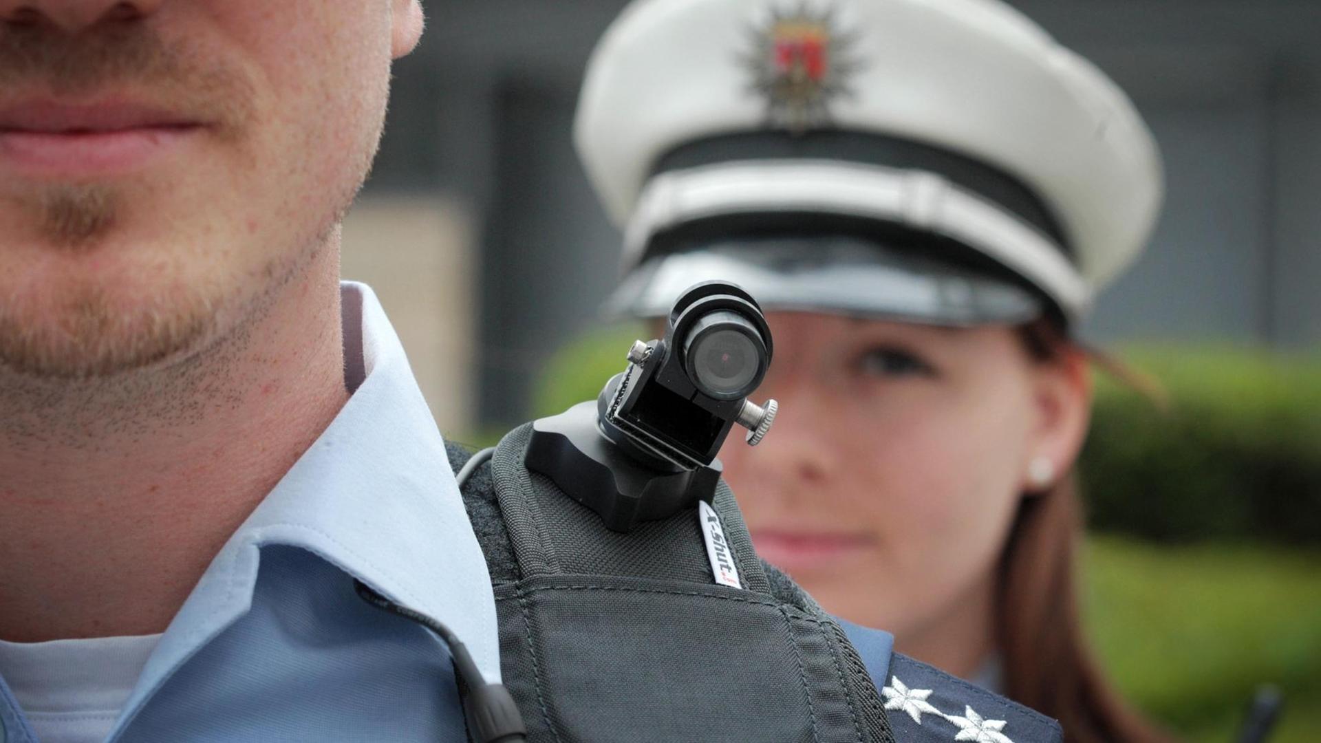 Ein Polizist trägt eine mobile Miniatur-Videokamera auf seiner Schulter. Ein Polizist trägt eine mobile Miniatur-Videokamera auf seiner Schulter.