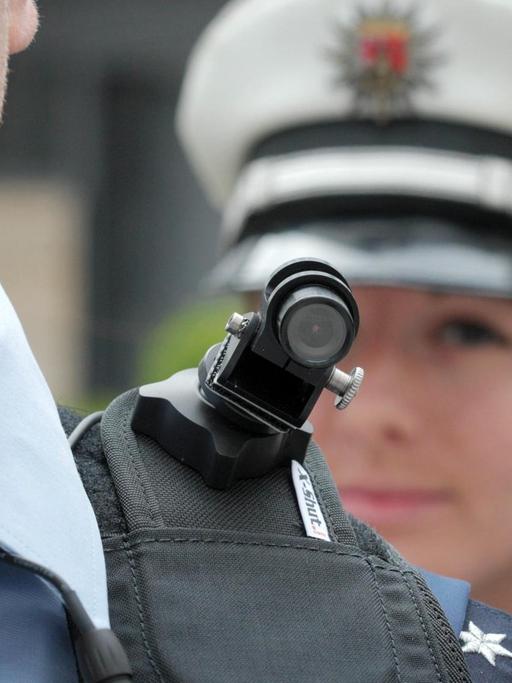 Ein Polizist trägt eine mobile Miniatur-Videokamera auf seiner Schulter.