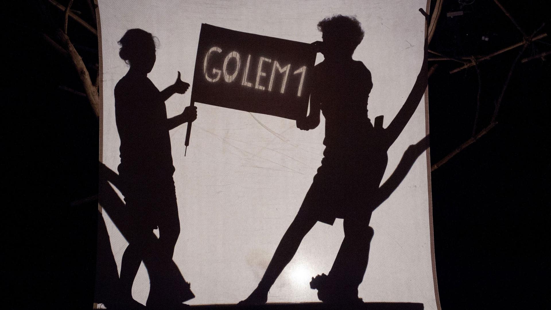 Die deutsche Schauspielerin Juliette Schenkel (l) und die italienische Schauspielerin Silvia Sassetti stehen am 18.07.2015 während der Fotoprobe für das Stummtheater "Golem" in Weimar (Thüringen) hinter einer Leinwand auf der Bühne.