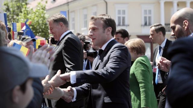 Frankreichs Präsident Macron schüttelt beim EU-Gipfel im rumänischen Sibiu Hände von Passanten.