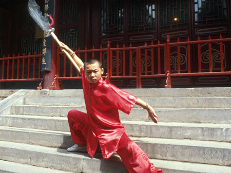 Ein junger Shaolin-Mönch bei einer Kampfkunst-Vorführung im berühmten Shaolin-Tempel in Songshan in der chinesischen Provinz Henan. Ein junger Shaolin-Mönch bei einer Kampfkunst-Vorführung im berühmten Shaolin-Tempel in Songshan in der chinesischen Provinz Henan.
