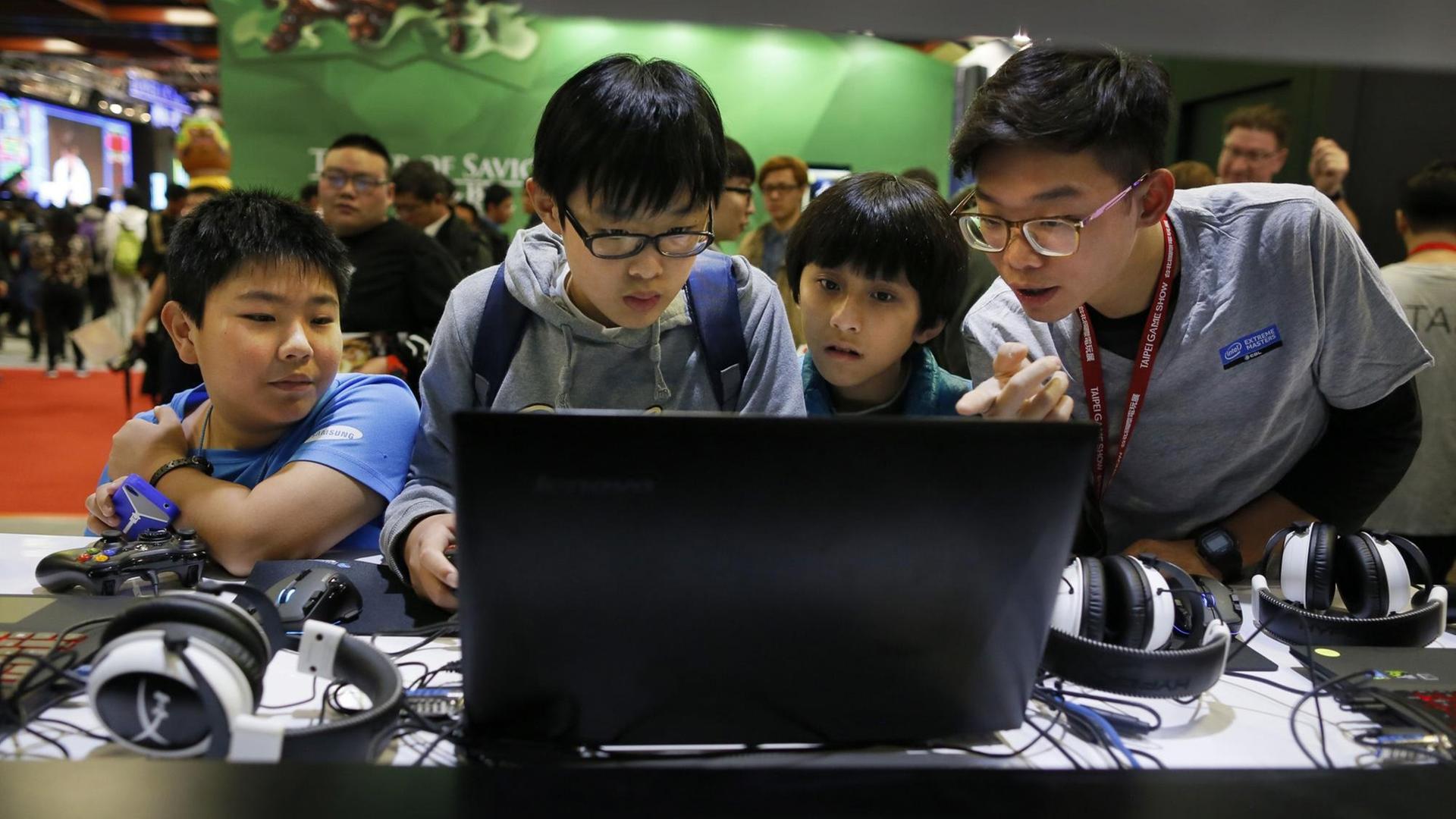 Vier Kinder in China drängen sich vor einen Computerbildschirm. Vier Kinder in China drängen sich vor einen Computerbildschirm.