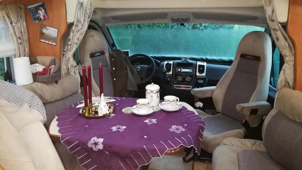 In einem Wohnmobil ist ein Kaffeetisch gedeckt. In einem Wohnmobil ist ein Kaffeetisch gedeckt.