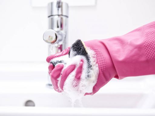 Eine Frau putzt ein Badezimmer.