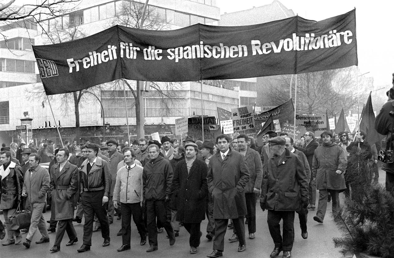 "Freiheit für die spanischen Revolutionäre" wird auf einem Transparent gefordert, das Teilnehmer einer Demonstration am 19. Dezember 1970 in Berlin mit sich tragen. Demonstration solidarisiert sich mit 16 baskischen Nationalisten, die sich ab dem 3. Dezember 1970 vor einem Militärgericht im spanischen Burgos wegen Mord und Terroraktionen verantworten mussten "Freiheit für die spanischen Revolutionäre" wird auf einem Transparent gefordert, das Teilnehmer einer Demonstration am 19. Dezember 1970 in Berlin mit sich tragen. Demonstration solidarisiert sich mit 16 baskischen Nationalisten, die sich ab dem 3. Dezember 1970 vor einem Militärgericht im spanischen Burgos wegen Mord und Terroraktionen verantworten mussten