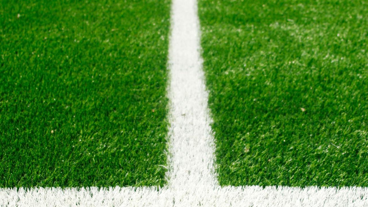 Ausschnitt von einem Fußballfeld mit weißen Linien auf grünem Rasen. Ausschnitt von einem Fußballfeld mit weißen Linien auf grünem Rasen.