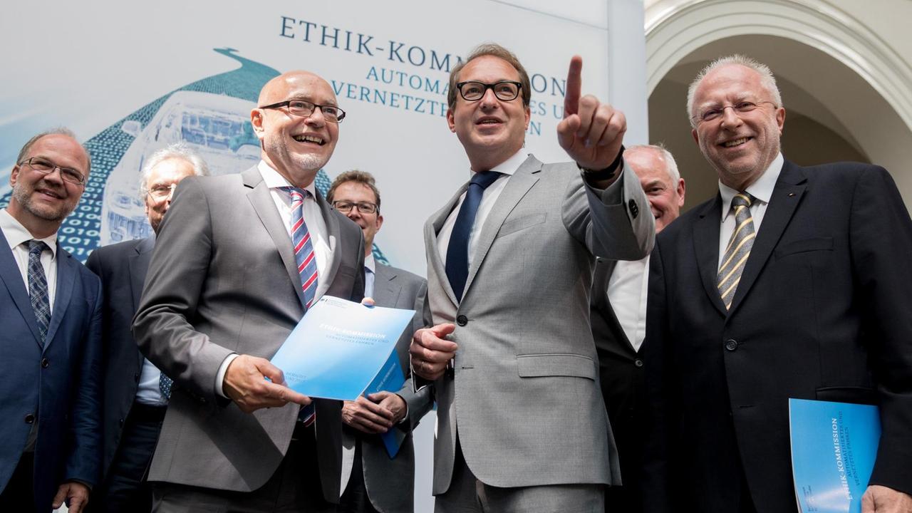 Der Rechtswissenschaftler Dirk Heckmann (links), der Jurist Udo di Fabio (2.von links) und der Physiker Armin Grunwald (rechts) überreichen den Bericht der Ethik-Kommission für selbstfahrende und vernetzte Autos an Bundesverkehrsminister Alexander Dobrindt (CSU).