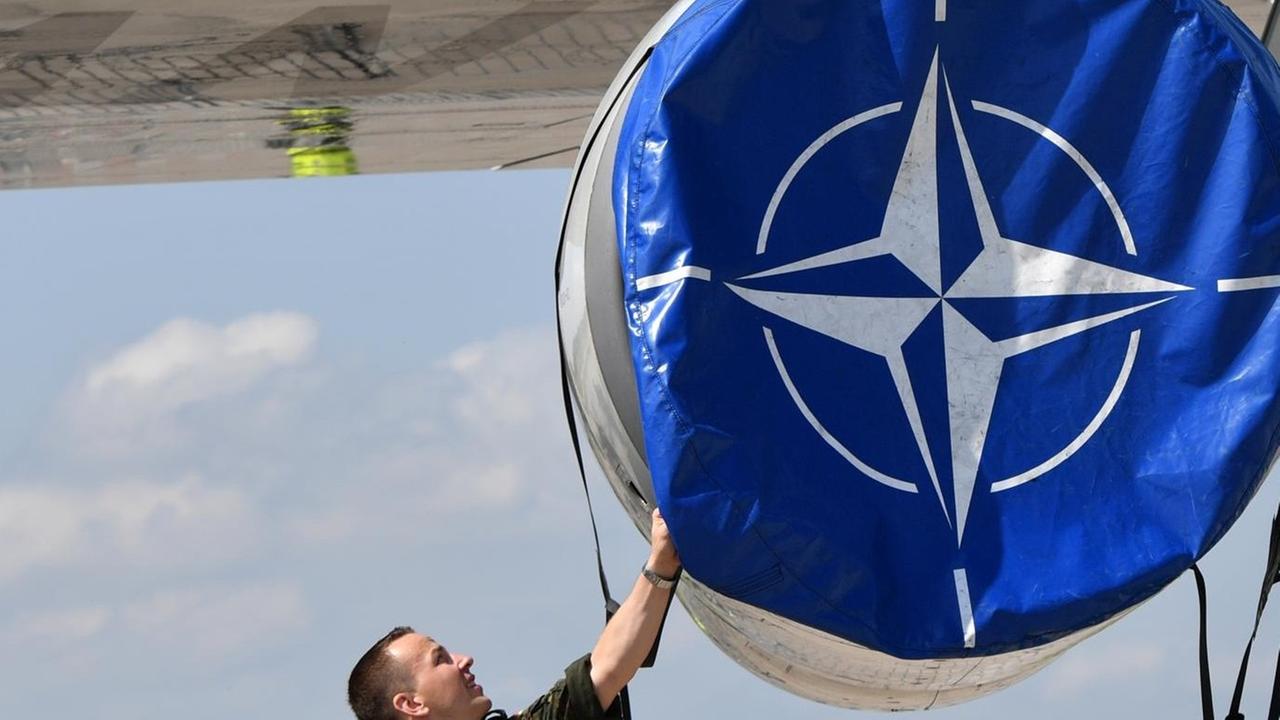 Mechaniker hanitieren in Schönefeld (Brandenburg) auf der Internationalen Luft- und Raumfahrtmesse ILA an einer Schutzhülle mit dem Logo der Nato an einem AWACS Aufklärungsflugzeug Mechaniker hanitieren in Schönefeld (Brandenburg) auf der Internationalen Luft- und Raumfahrtmesse ILA an einer Schutzhülle mit dem Logo der Nato an einem AWACS Aufklärungsflugzeug