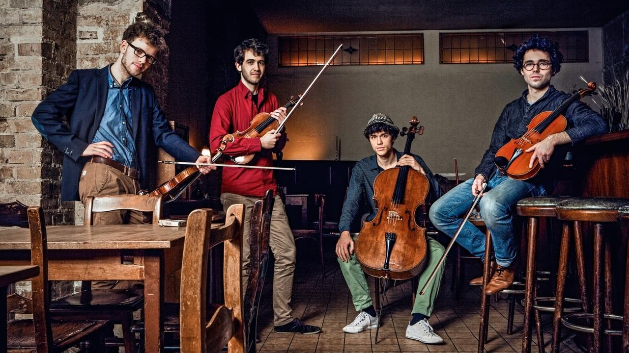 Die vier Musiker sitzen mit ihren Instrumenten in einer alten Kneipe. Die vier Musiker sitzen mit ihren Instrumenten in einer alten Kneipe.