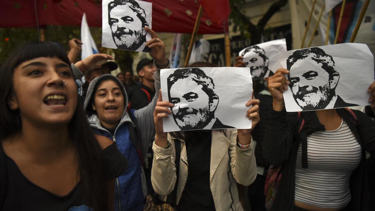 Demonstranten halten Bilder des Politikers Lula da Silva hoch . Demonstranten halten Bilder des Politikers Lula da Silva hoch .