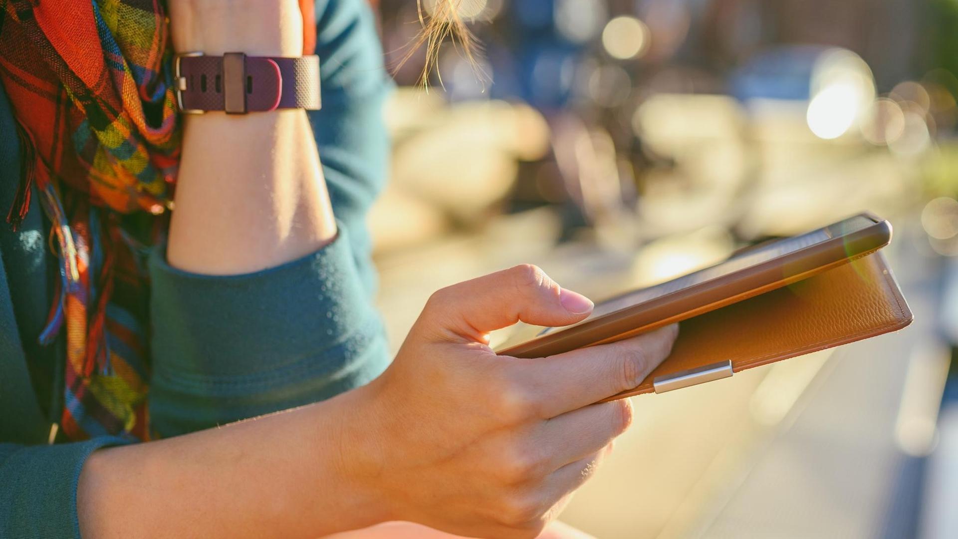 Eine Frauenhand hält einen E-Book-Reader. Eine Frauenhand hält einen E-Book-Reader.