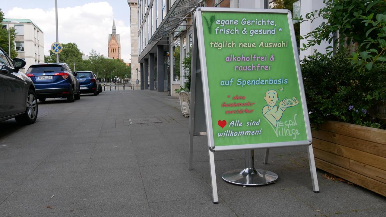 Ein Aufsteller auf dem Gehweg wirbt für das Angebot des Restaurants, im Hintergrund ist die Marktkirche zu sehen Ein Aufsteller auf dem Gehweg wirbt für das Angebot des Restaurants, im Hintergrund ist die Marktkirche zu sehen