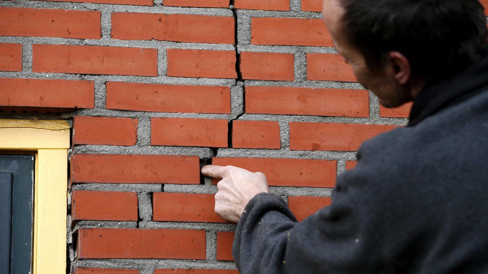 Ein Bewohner von Doodstil in den Niederlanden zeigt einen Riss in der Wand seines Hauses, der durch Erdbeben verursacht wurde