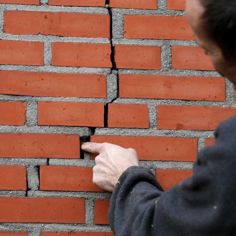 Ein Bewohner von Doodstil in den Niederlanden zeigt einen Riss in der Wand seines Hauses, der durch Erdbeben verursacht wurde