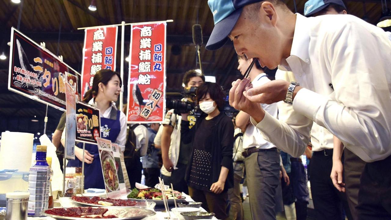 Walfleischauktion im August in Sendai im Nordosten Japans. Ein Mann probiert rohes Walfleisch. Walfleischauktion im August in Sendai im Nordosten Japans. Ein Mann probiert rohes Walfleisch.
