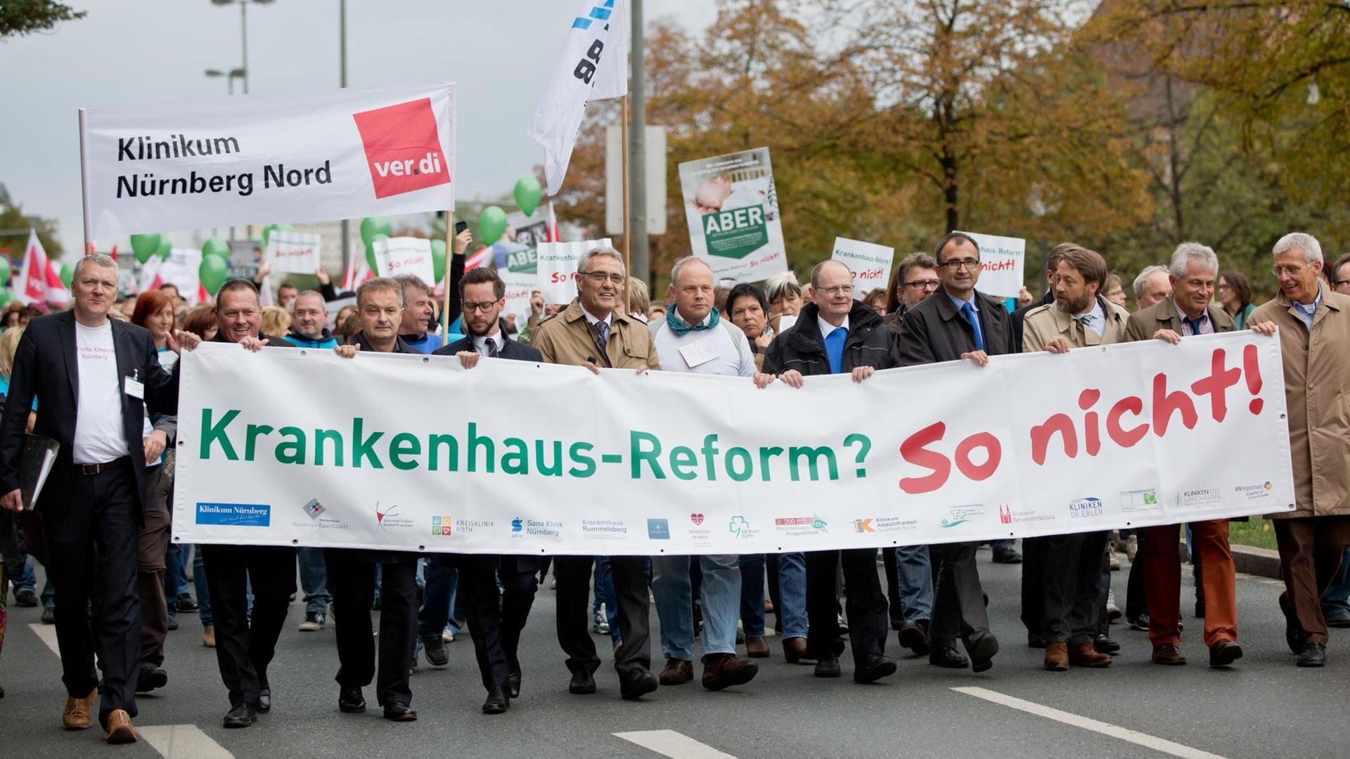 Geschäftsführer Mittelfränkischer Kliniken tragen am 23.09.2015 in Nürnberg (Bayern) einen Banner mit der Aufschrift "Krankenhaus-Reform? So nicht!". Mehrere hundert Klinikmitarbeiter protestierten gegen die bevorstehende Krankenhausreform.