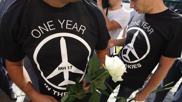 Menschen gedenken ein Jahr nach dem Abschuss der Boeing mit der Flugnummer MH17 über der Ost-Ukraine vor der niederländischen Botschaft in Kiew der Opfer
