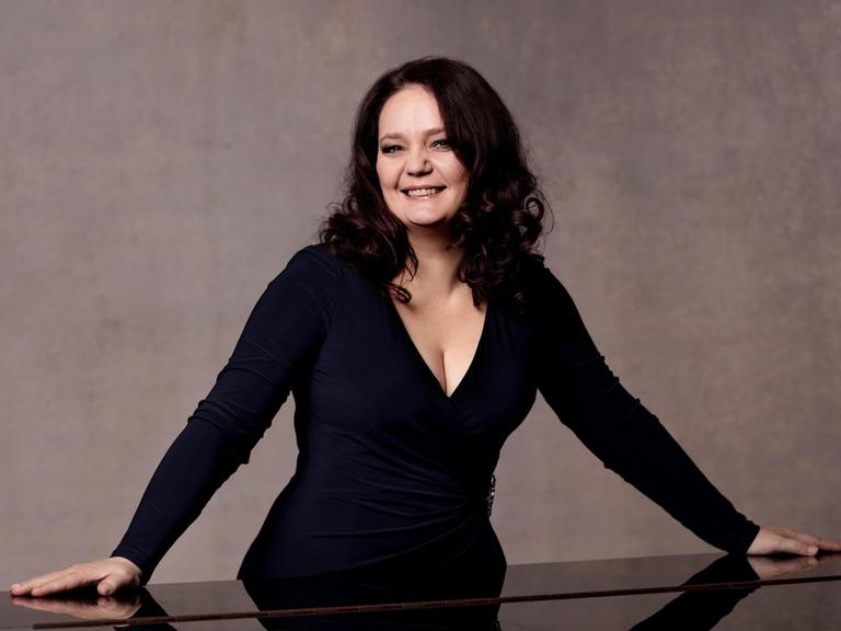 Die Pianistin Ana-Marija Markovina lehnt sich auf einen Flügel.