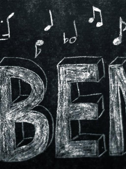 Das Wort "Üben" steht auf einer Tafel, umgeben von Noten