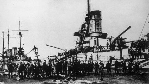 Die deutsche Marine verweigert das Auslaufen. Soldaten/Matrosen vor einem Kriegsschiff.