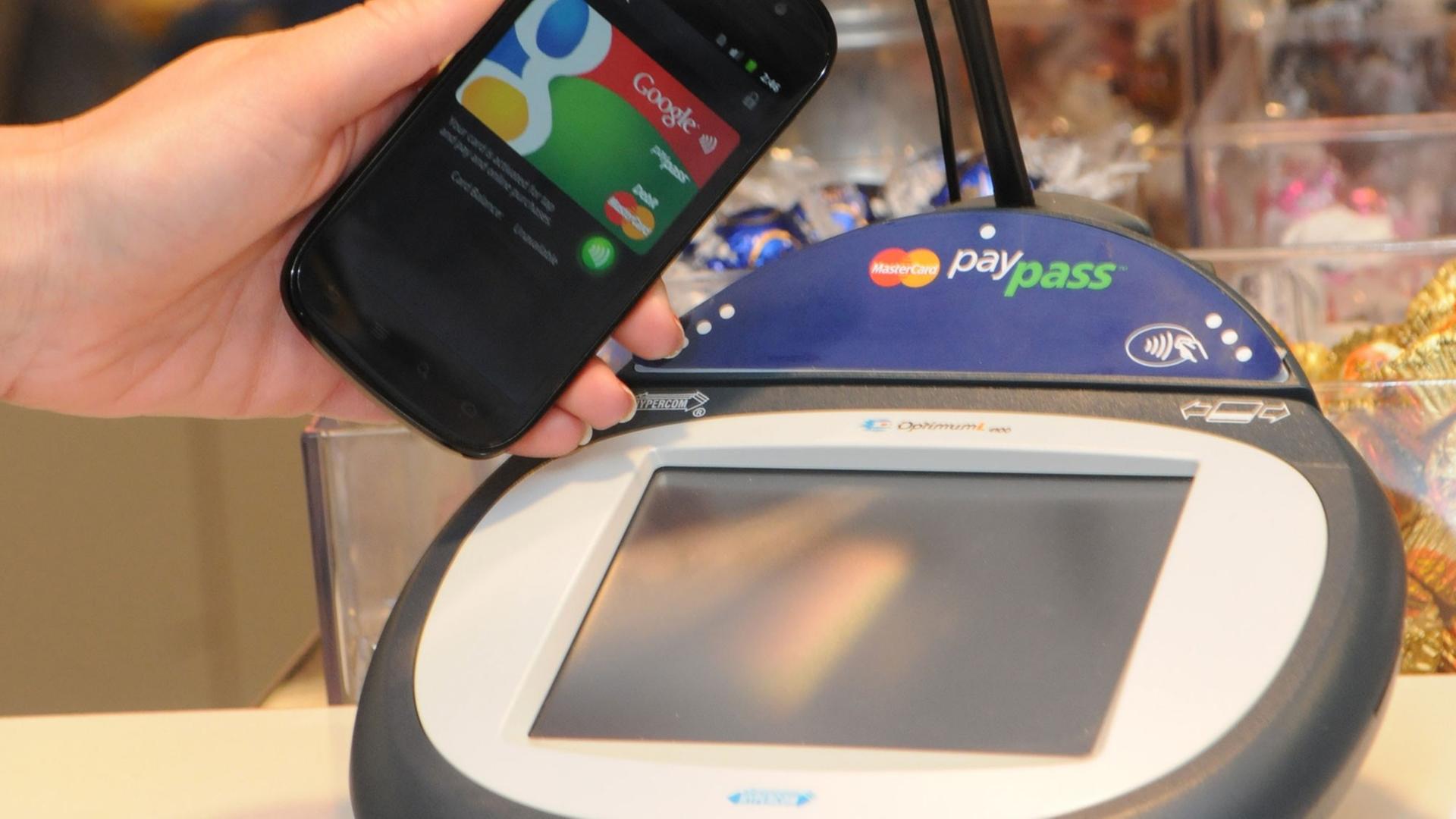 Ein Google-Smartphone wird an einer Supermarkt-Kasse neben ein so genanntes PayPass Gerät zur elektronischen Zahlungsabwicklung gehalten (undatiertes Google-Handout). Statt des dicken Portemonnaies soll bald nur noch ein schlankes Smartphone ausreichen. Ein Google-Smartphone wird an einer Supermarkt-Kasse neben ein so genanntes PayPass Gerät zur elektronischen Zahlungsabwicklung gehalten (undatiertes Google-Handout). Statt des dicken Portemonnaies soll bald nur noch ein schlankes Smartphone ausreichen.