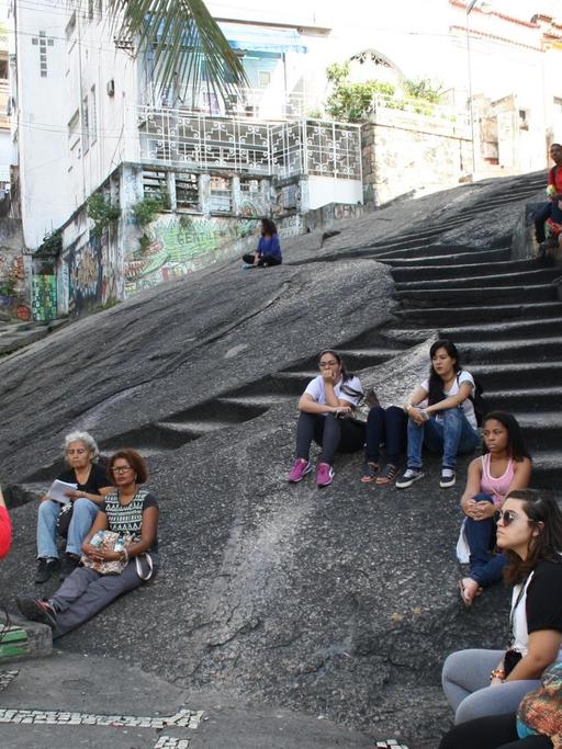 Menschen sitzen auf einer Treppe.