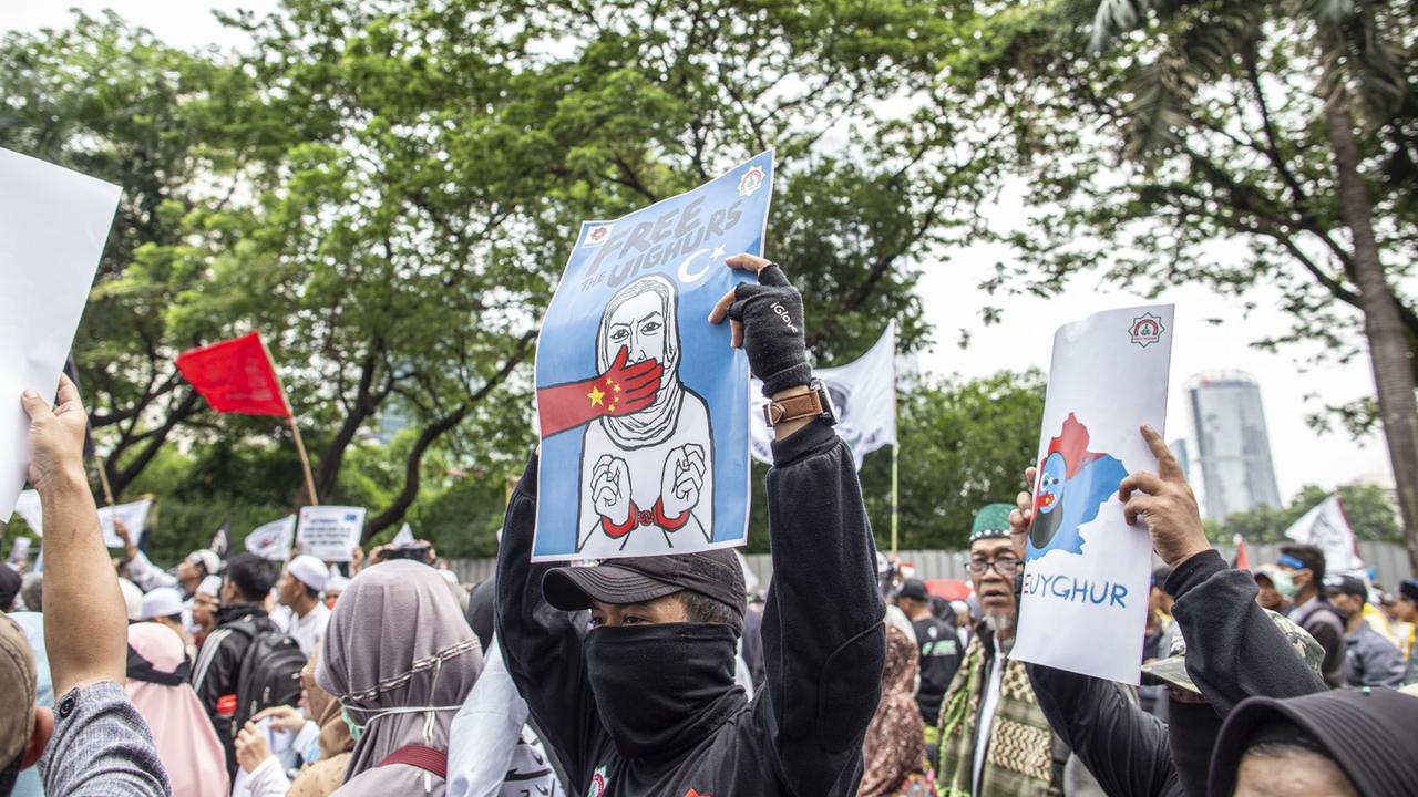 Tausenden Muslime protestieren vor der chinesischen Botschaft in Jakarta, Indonesien. "Stoppt den Genozid" und "Befreit die Uiguren" steht auf den Schildern. 27.12.2019.