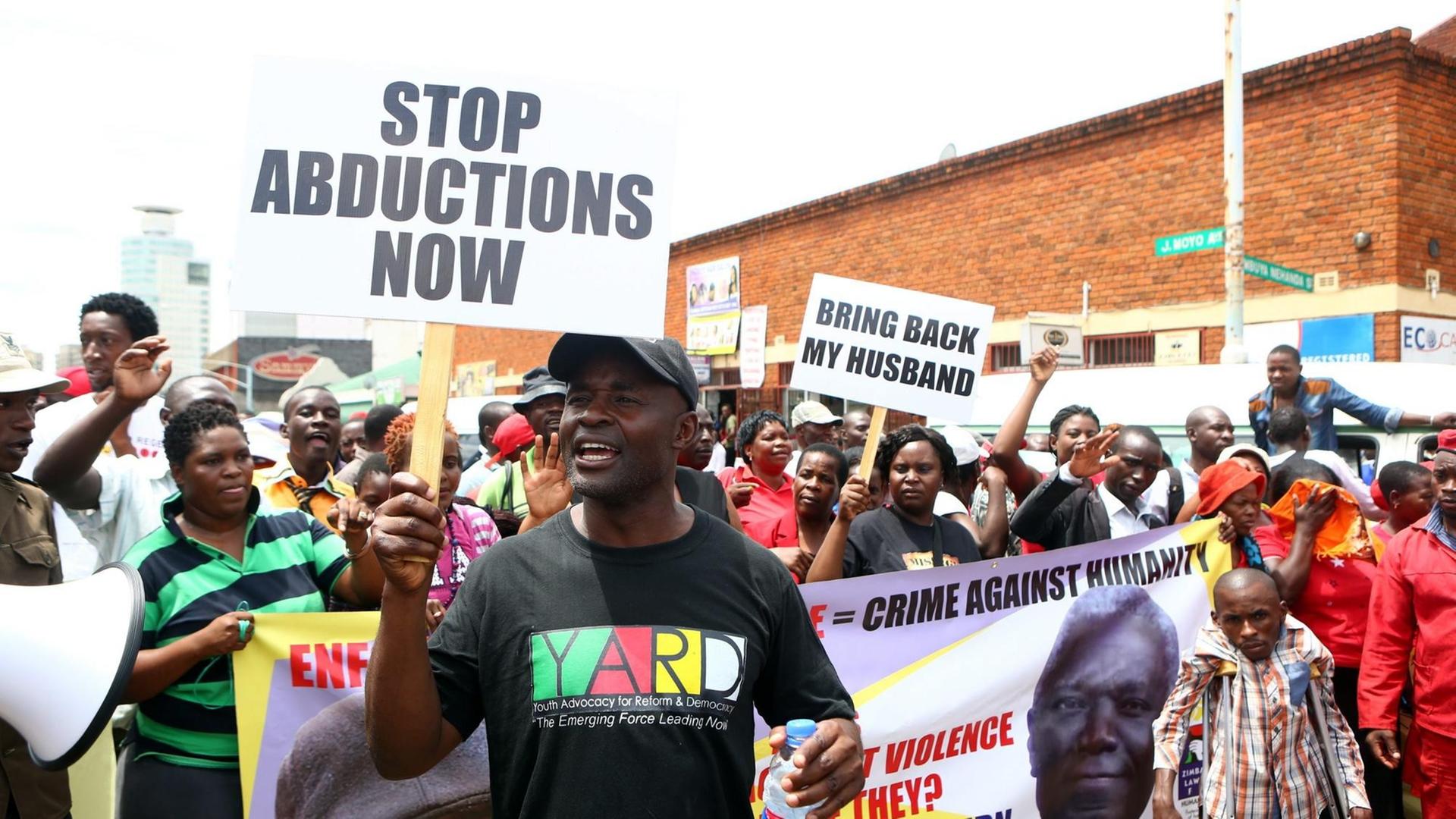 Demonstranten halten in Simbabwe im März 2016 Schilder in die Luft, die eine Aufklärung der Entführung des Journalisten und Aktivisten Itai Dzamara fordern, der 2015 verschleppt wurde und seitdem verschwunden ist. Demonstranten halten in Simbabwe im März 2016 Schilder in die Luft, die eine Aufklärung der Entführung des Journalisten und Aktivisten Itai Dzamara fordern, der 2015 verschleppt wurde und seitdem verschwunden ist.