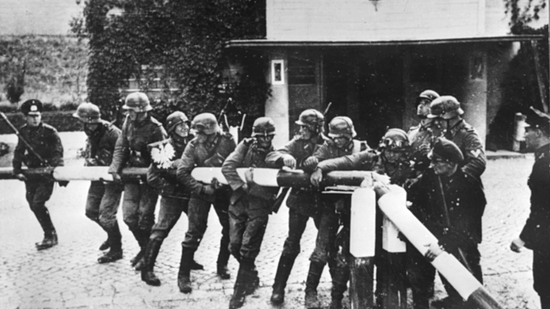 Beim Einmarsch deutscher Truppen in Polen am 01.09.1939 reißen Soldaten der deutschen Wehrmacht einen rot-weißen Schlagbaum an der deutsch-polnischen Grenze nieder. Beim Einmarsch deutscher Truppen in Polen am 01.09.1939 reißen Soldaten der deutschen Wehrmacht einen rot-weißen Schlagbaum an der deutsch-polnischen Grenze nieder.