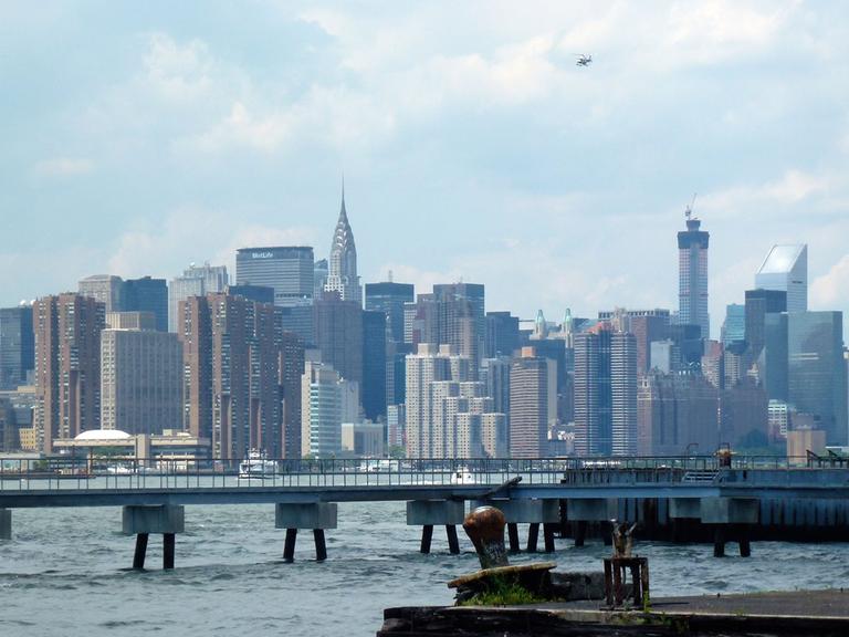 Blick auf den East River mit Manhattan im Hintergrund, aufgenommen vom Ufer in Williamsburg, Brooklyn, New York am 22.06.2014.