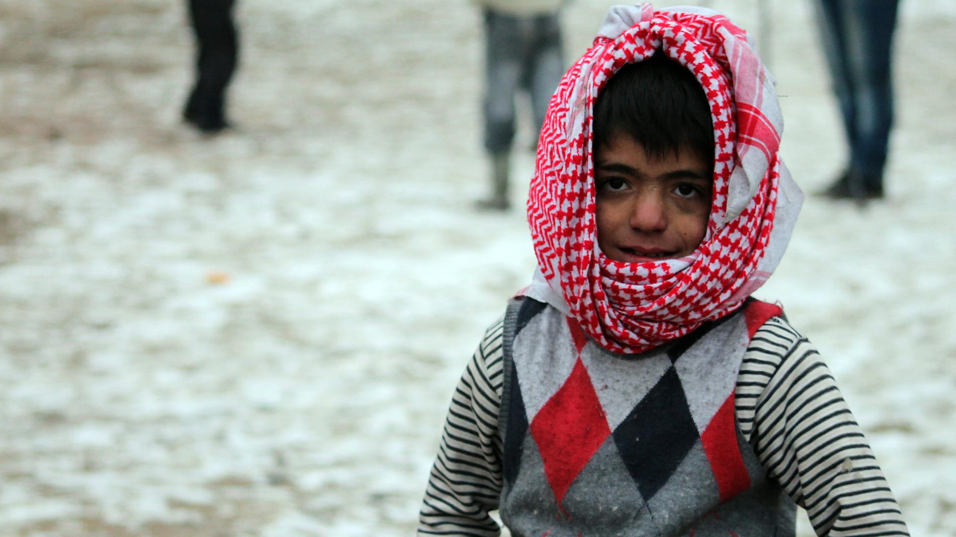 Ein Junge spielt in der syrischen Stadt Aleppo im Schnee.