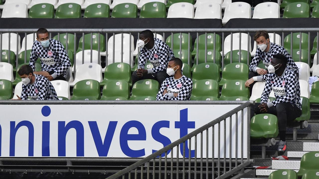 Ersatzspieler von Eintracht Frankfurt auf der Tribüne mit Mundschutz. Ersatzspieler von Eintracht Frankfurt auf der Tribüne mit Mundschutz.