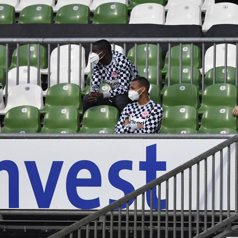Ersatzspieler von Eintracht Frankfurt auf der Tribüne mit Mundschutz.