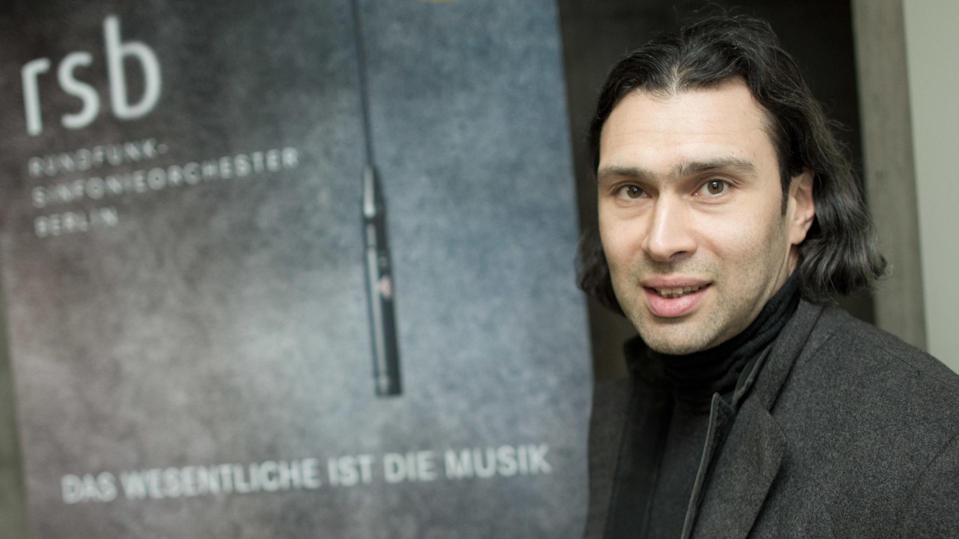 Der Dirigent steht neben einem Aufsteller, auf dem der Schriftzug "rsb" zu lesen ist. Der Dirigent steht neben einem Aufsteller, auf dem der Schriftzug "rsb" zu lesen ist.
