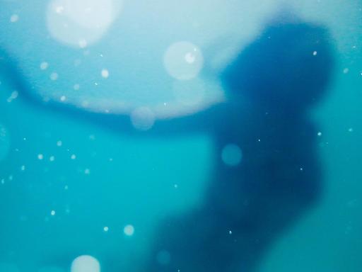 Junge Frau unter Wasser mit Wasserblasen.