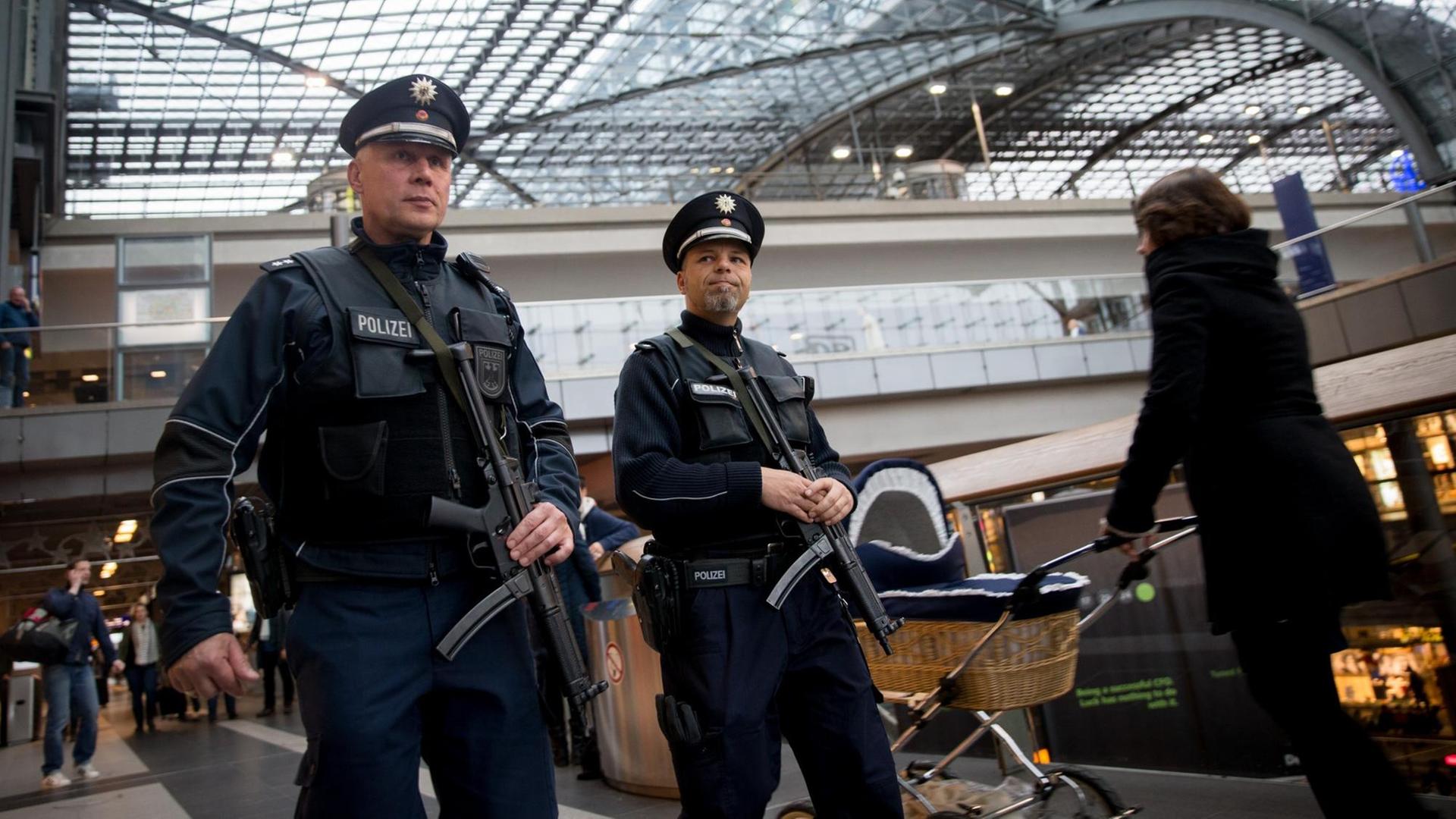Zwei Beamte der Bundespolizei patrouillieren schwer bewaffnet im Berliner Hauptbahnhof. Zwei Beamte der Bundespolizei patrouillieren schwer bewaffnet im Berliner Hauptbahnhof.