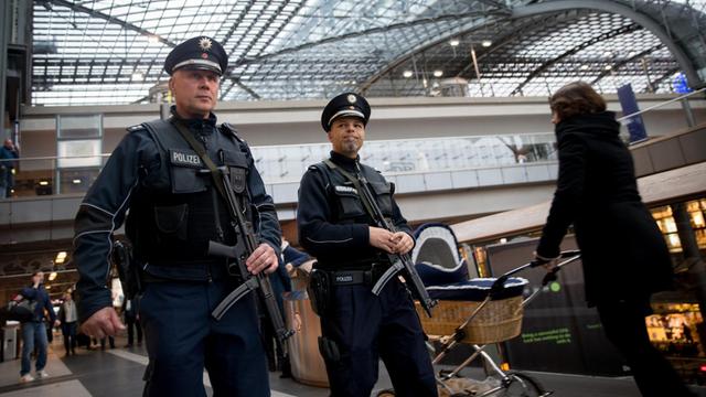 Zwei Beamte der Bundespolizei patrouillieren schwer bewaffnet im Berliner Hauptbahnhof.