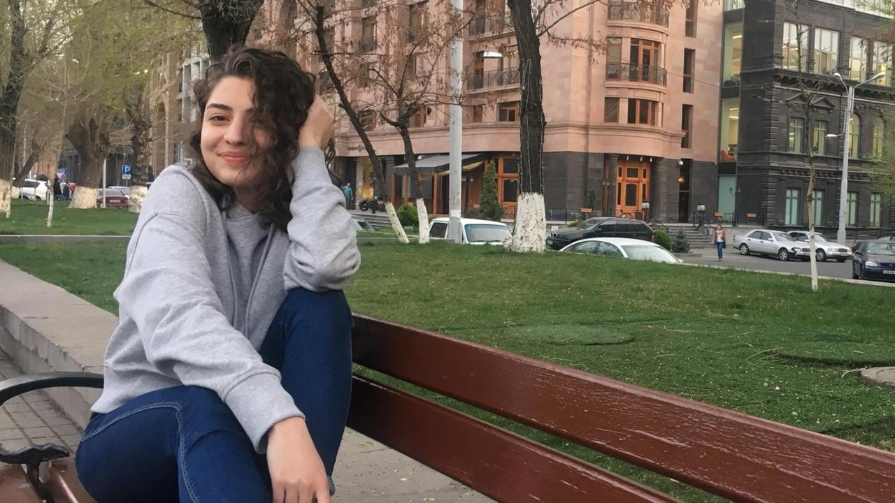 Yana sitzt auf einer Parkbank und lacht. Yana sitzt auf einer Parkbank und lacht.