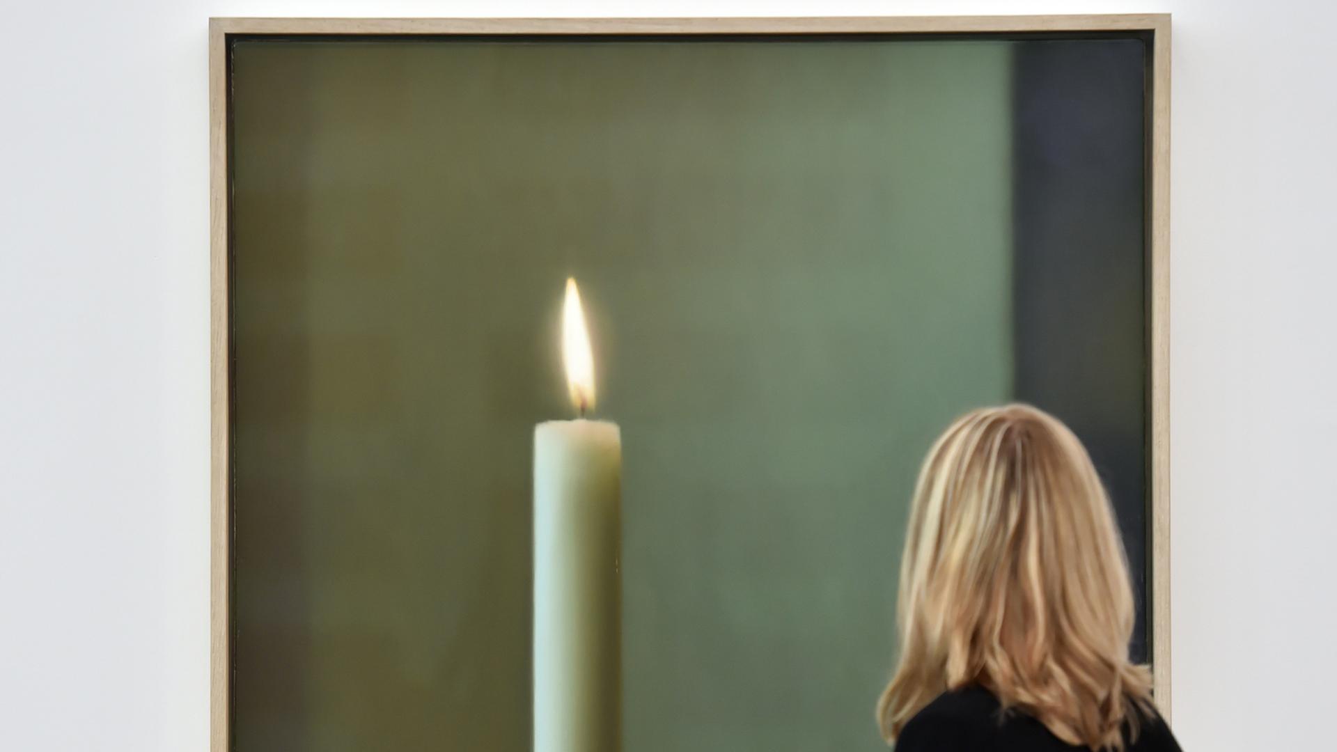 Eine Besucherin der Ausstellung betrachtet Gerhard Richters Werk "Kerze", ein Bild mit einer großen Kerze drauf, Frau ist nur von hinten zu sehen. Eine Besucherin der Ausstellung betrachtet Gerhard Richters Werk "Kerze", ein Bild mit einer großen Kerze drauf, Frau ist nur von hinten zu sehen.