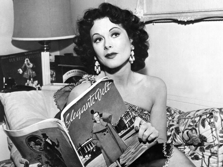 Die amerikanische Schauspielerin Hedy Lamarr blättert in der "Eleganten Welt" (undatiert). Hedy Lamarr, die in den 30er Jahren als "exotischer Sex-Star" in Hollywood Ruhm erlangte, ist am 19.1.2000 tot in ihrem Haus bei Orlando in Florida aufgefunden worden. Die gebürtige Österreicherin starb im Alter von 86 Jahren. Lamarr bekam aus Hollywood erste Rollenangebote, nachdem sie 1933 für einen Moment fast nackt in dem tschechischen Film "Ekstase" zu sehen gewesen war. Viele Jahre war die Ehefrau eines österreichischen Waffenhändlers danach in den USA auf die Rolle der "schönen Exotin" festgelegt. Sie war aber auch als Erfinderin tätig. 1942 erhielt Lamarr das Patent für eine spezielle Funktechnik. Das Verfahren wurde später bei der Entwicklung von Handys genutzt.