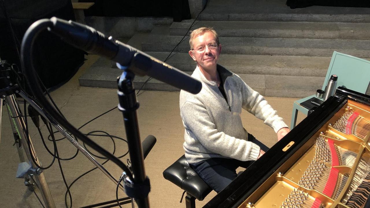 Blick von oben auf ein Klavier mit Pianisten, auf den Mikrophone gerichtet sind. Blick von oben auf ein Klavier mit Pianisten, auf den Mikrophone gerichtet sind.