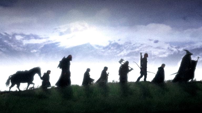 Filmszene aus "Herr der Ringe - Die Gefährten": Eine Gruppe von Wanderern ist als Schattenriss zu sehen. Filmszene aus "Herr der Ringe - Die Gefährten": Eine Gruppe von Wanderern ist als Schattenriss zu sehen.