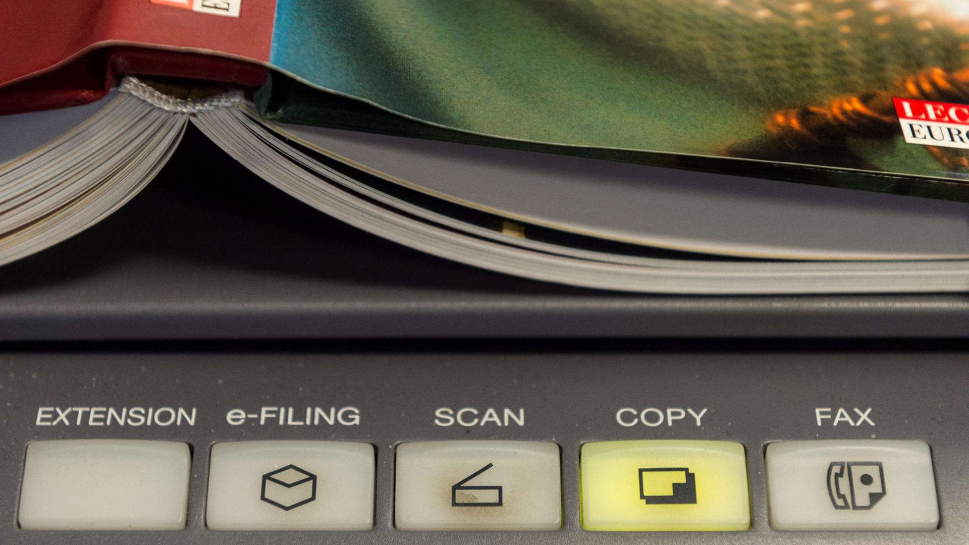 Ein Buch liegt auf einem Scanner. Ein Buch liegt auf einem Scanner.