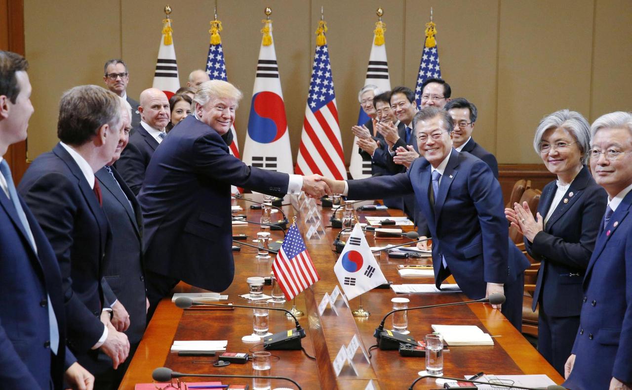 Trump und Moon stehend am Konferenztisch, schütteln die Hände.
